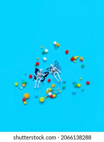 winged skeletons and colorful decorative balls on abstract blue background. artistic magic image. creative art surreal concept. symbol of Halloween holiday. minimal style. copy space. flat lay