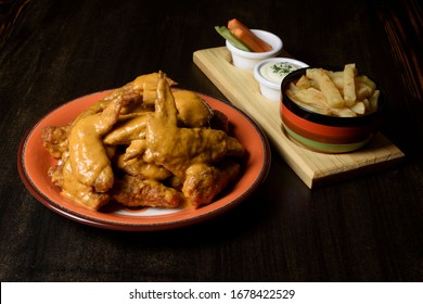 Wings In Honey Mustard Sauce With A Side Of French Fries And Vegetables With Sour Sauce