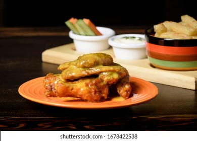 Wings In Honey Mustard Sauce With A Side Of French Fries And Vegetables With Sour Sauce