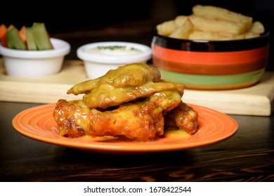 Wings In Honey Mustard Sauce With A Side Of French Fries And Vegetables With Sour Sauce