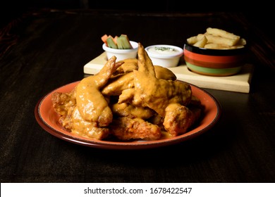 Wings In Honey Mustard Sauce With A Side Of French Fries And Vegetables With Sour Sauce