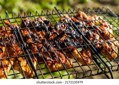 Wings In Marinade And Soy Sauce Are Fried On A Smoky Grill. Horizontal Photo