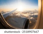 Wingview of a Modern Jet Aircraft in Golden Evening Sunlight Above the Clouds