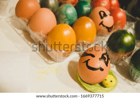 Winking easter egg between other collored eggs. Easter celebration and egg hunt concept.