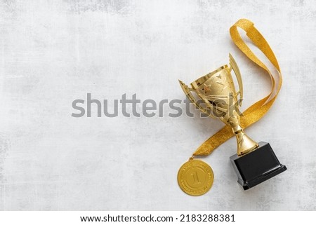 Winner concept with gold medal first place and award trophy cup