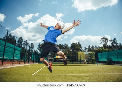 I Am Winner. Full Length Portrait Of Satisfied Young Child Waving Arms While Jumping On Field For Tennis Game