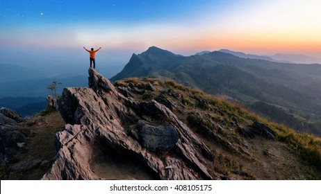 Winner man on peak of rocks mountain Hike at sunset, Active life concept