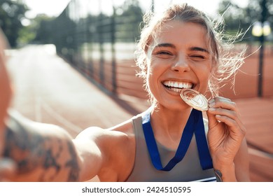 Winner woman in sportswear with number showing gold medal for first place and celebrating. Sports,  victory concept. - Powered by Shutterstock