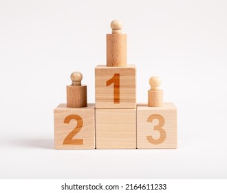 Winners Podium From Wooden Blocks With Knobbed Cylinders And Numbers 1, 2, 3. Hierarchy, Ranking Concept. Distribution Of Places Among Competition Champions. High Quality Photo