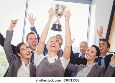 Winning Business Team With A Woman Executive Holding A Gold Trophy