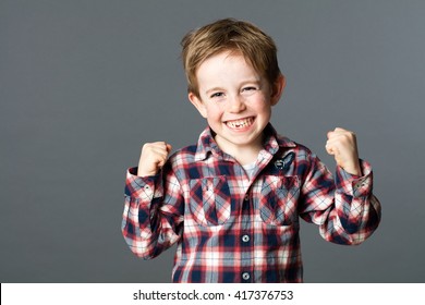 Winning Kid - Winning Young Red Hair Child With A Tooth Missing Raising His Arms For Happiness And Excitement, Grey Background Studio
