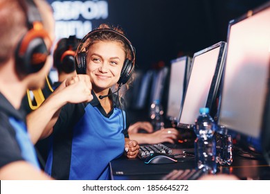 Winning. Two young happy professional cyber sport gamers giving fist bump and celebrating success while participating in eSports tournament - Shutterstock ID 1856645272