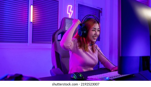 Winning. Young woman in gaming headphones playing video game online at home neon room feel excited, Happy Gamer young plays online video games computer she raises hands to wins tournament, E-Sport - Shutterstock ID 2192523007