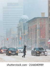 Winnipeg, MB, Canada - April 2022: Person Crossing The Street During A Blizzard