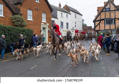 WINSLOW, UK - December 26, 2018. Fox Hunting, Men In Costume Riding On Horses With A Pack Of Hounds Through A Rural Town In Buckinghamshire, England