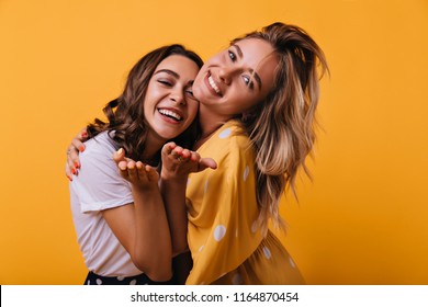 Winsome White Girls Posing In Studio With Smile. Lovable Caucasian Female Friends Relaxing During Photoshoot.