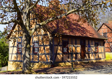 WINSTON-SALEM, USA, MAR 2017: Old Wooden House With A Tree Throwing Shadows Across It In The Morning Sun, In The Traditional Moravian Settlement At Old Salem Museums And Gardens.