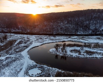 Winter Aerial View On Snowy River Curve. Zmiyevsky Region On Siverskyi Donets River In Ukraine. Sunset Sun Shining Above Woody Hill