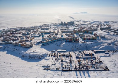 Winter aerial view of a snow-covered city in the Arctic. Top view of the seaport, seaside town, coastline and tundra. Severe cold arctic climate. City of Anadyr, Chukotka, Siberia, Far North of Russia