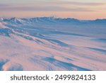 Winter arctic landscape. Cold frosty winter weather. Harsh polar climate. Ice hummocks on the frozen sea in the Arctic. View of snow and ice at sunset. Picturesque nature of the Arctic. Far North.