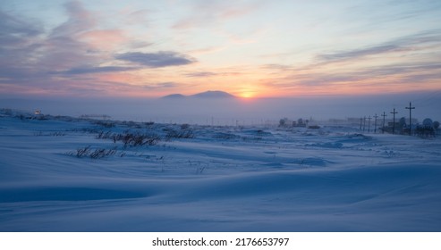 Winter arctic landscape. Sunset in the tundra. Early winter twilight. Cold frosty winter weather. Electric poles and satellite dishes in the snowy tundra. Chukotka, Siberia, Far East of Russia, Arctic - Shutterstock ID 2176653797