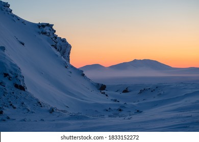 Winter arctic landscape. View of the snow-covered tundra and mountains. Very cold frosty weather in February in the far north of Russia. The nature of Chukotka and polar Siberia. Harsh arctic climate.