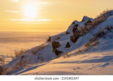 Winter Arctic Landscape. View From The Snow-covered Rocky Slope Of The Mountain At A Beautiful Sunrise Over The Tundra. Cold Windy And Frosty Weather. Chukotka, Polar Siberia, The Far North Of Russia.