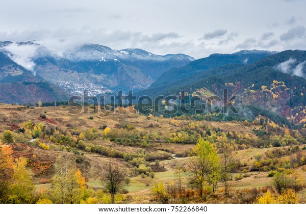 Winter in\
the autumn landscape. Bulgarian Rodopi mountain colored by fall and\
winter. A village tucked away among\
hills