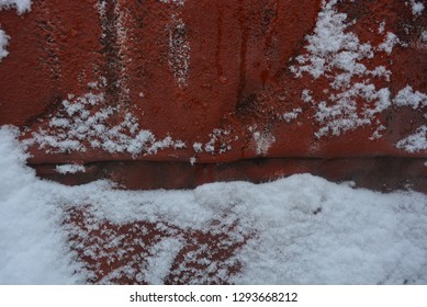 Winter Background, Adhering Snow, Beautiful Cut Of Heavy Snow On A Metal Construction Sheet, Painted With Old Red Paint With Mounds And Valleys