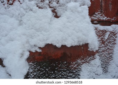 Winter Background, Adhering Snow, Beautiful Cut Of Heavy Snow On A Metal Construction Sheet, Painted With Old Red Paint With Mounds And Valleys