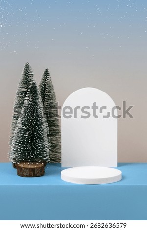 Winter background with cylindrical empty podium display for promotions and for showing product decorate. Stage pedestal or platform between Xmas trees on blue table. Merry Christmas celebration.
