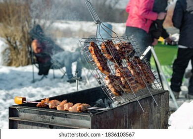 Winter barbecue outdoors, grill steak and fork with meat over hot coals in a BBQ at campside cookout, camping lifestyle