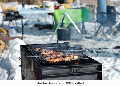 Winter barbecue party outdoors, grill steak meat over hot coals in BBQ at campsite cookout, close up view, camping mood