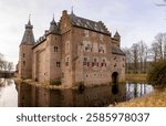 Winter barren floodplains Dutch landscape with moated exterior facade of Doorwerth castle in province of Gelderland