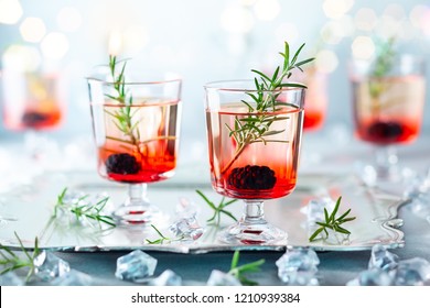 Winter berry cocktails made with blackberry liqueur and gin for Christmas or New Year. Served with fresh blackberry and rosemary on the silver tray.