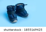Winter blue warm boots for newborns on light blue background flat lay copy space. Children