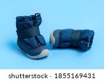Winter blue warm boots for newborns on light blue background flat lay copy space. Children
