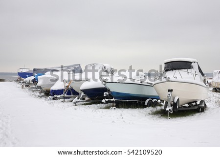 Winter boats parking - average boats on trailers in snow.