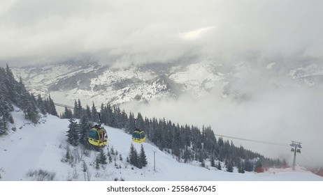 A winter cable car ride through the mountains. Winter Wonderland: cable cars that climb through snowy peaks and fog. A misty mountain top with stunning views in the resort of Borsa Complex, Maramures - Powered by Shutterstock