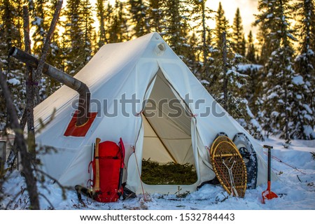 Winter camping in a tent.  Canadian wilderness in cold weather.  Adventure and snowshoeing