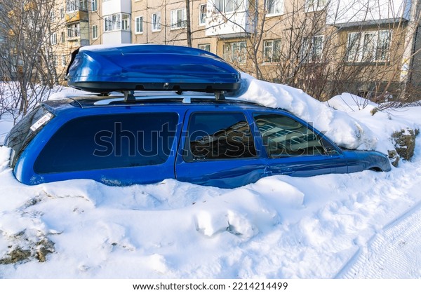 In winter, the car is covered with snow. The\
car is under a snowdrift. An abandoned old car in the yard in\
winter. Winter in the city. The fallen snow filled up the car. Snow\
drift in a blizzard.