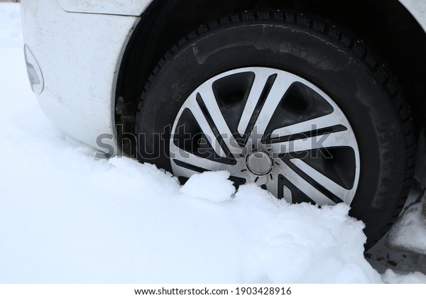 In winter, the car got stuck\
in deep snow. Car, winter, concept - car studded wheel in deep\
snow.