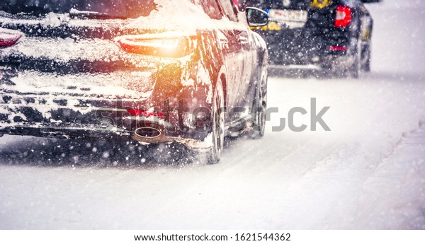 Winter car; Snow; Blizzard. Poor visibility on the\
road. Car during a Blizzard on the road with the headlights.\
Countryside during snow\
storm.