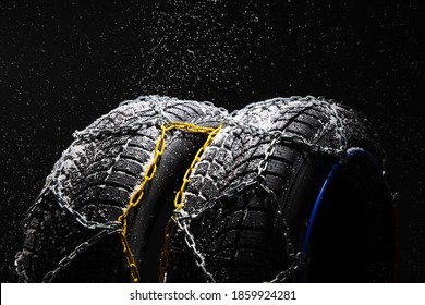 Winter Car tire with snow chains on black background. Winter season.