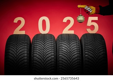 Winter car tires, big wheels service and hand of mechanic man with wrench and christmas tree ball on red new year 2025 background - Powered by Shutterstock