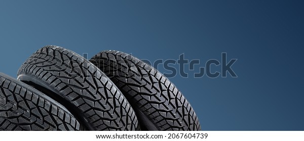Winter car tires. Group of tires for winter
driving on a blue
background.