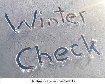 Winter Check drawn on a car windshield covered with fresh snow and ice