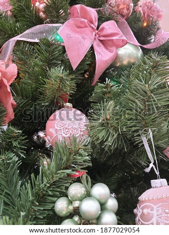 Winter Christmas background: green Christmas tree decorated with pink balls and toys, new year decorations, barbie style