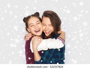 Winter, Christmas, People, Teens And Friendship Concept - Happy Smiling Pretty Teenage Girls Or Friends Hugging Over Gray Background And Snow