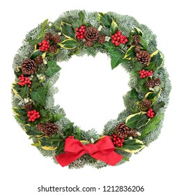 Winter and Christmas wreath with snow covered spruce pine fir, red bow, mistletoe, pine cones, cedar and ivy leaves isolated on white background. - Powered by Shutterstock